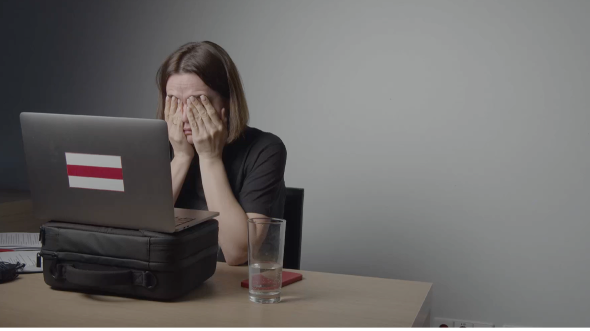 Sieviete, aizsegusi ar plaukstām seju, sēž pret datoru