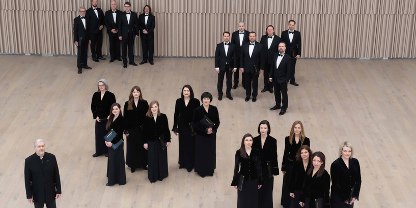 Kora dziedātāji melnos tērpos ar diriģentu Sigvardu Kļavu