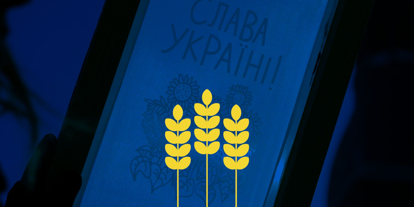 Pasākuma plakāts - uz zila fona sietspiede ar uzrakstu Slava Ukrainai un trīs dzeltenām vārpām