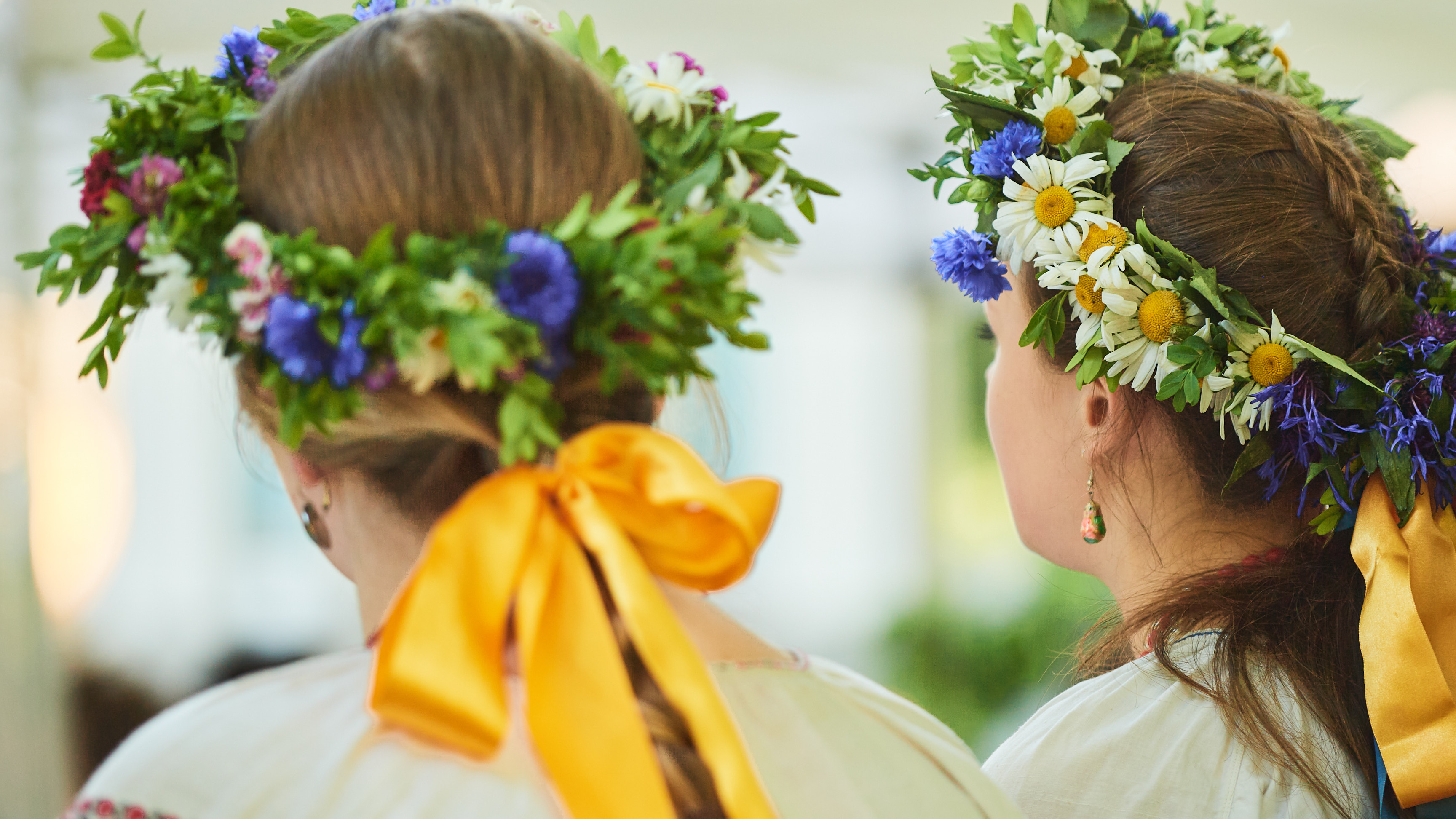 Meitenes ar tradicionāliem Jāņu vainagiem galvās