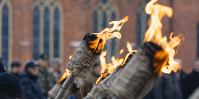 Degošas lāpas uz Rīgas doma sarkano ķieģeļu fona